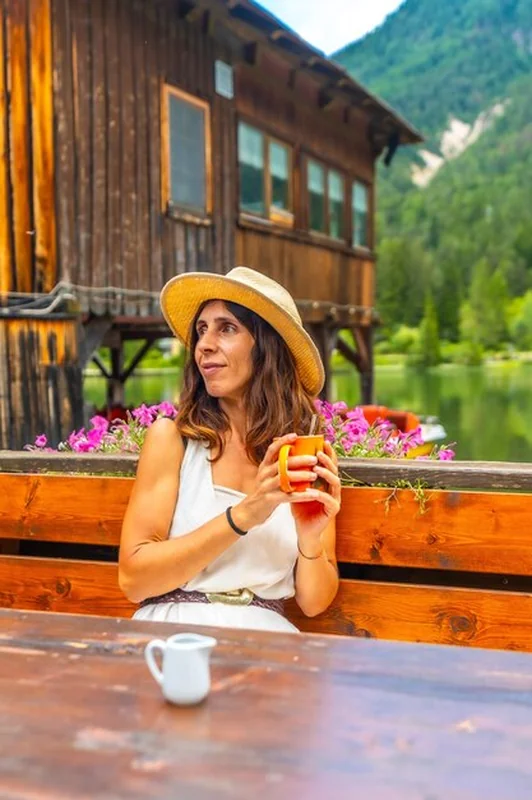 Turysta pijący gorący napój nad jeziorem Dobbiaco we Włoszech