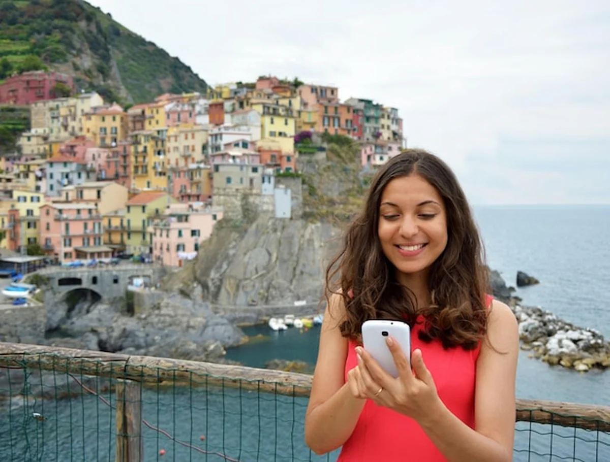 Młoda kobieta używająca smartfonu nad morzem