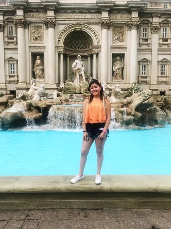 Uśmiechnięta kobieta przed fontanną Trevi