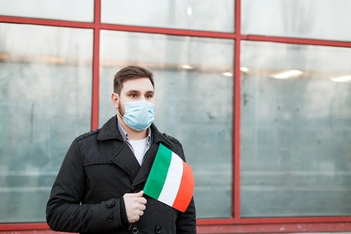 Mężczyzna w masce medycznej z włoską flagą