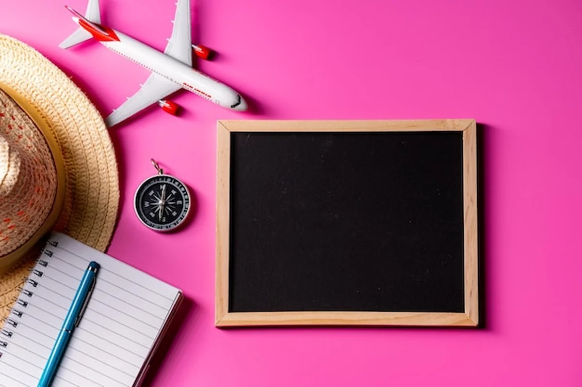 Letni weekendowy wyjazd z akcesoriami podróżnymi na różowym tle