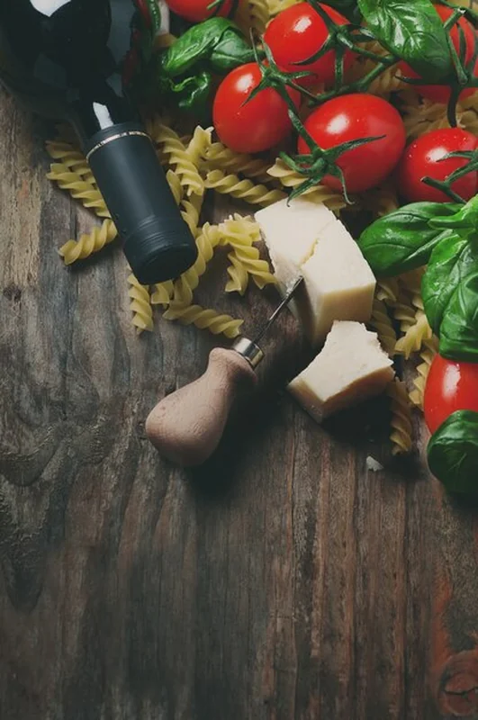 Włoskie jedzenie z surowym fusilli, pomidorem, bazylią, serem