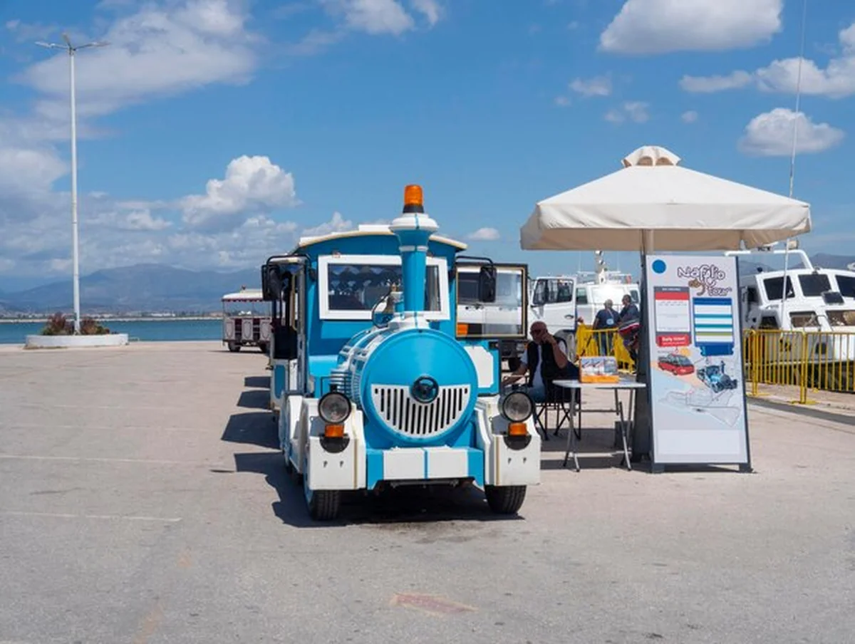 Pociąg turystyczny z turystami na ulicy w Nafplion, Grecja